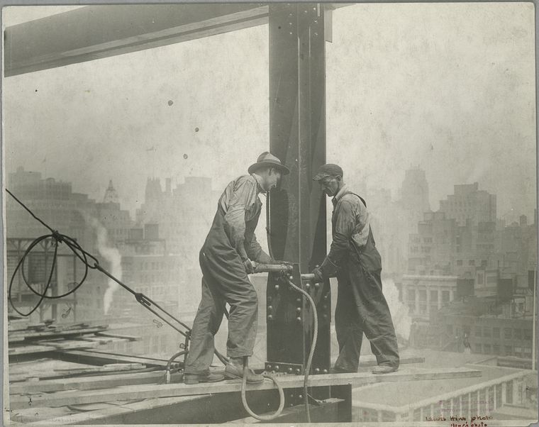 Two workers securing a rivet
