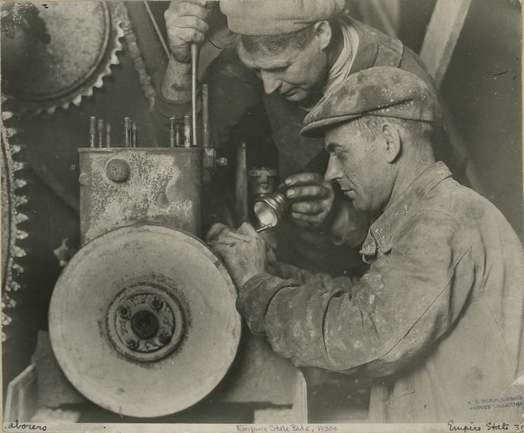 Two workers repairing machinery