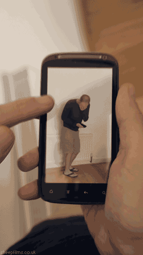 gifs - illusion man looking at a phone