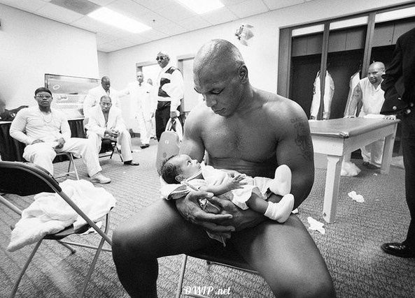 Mike Tyson in the dressing room with his two-month old son Miguel after losing to Lennox Lewis in 2002