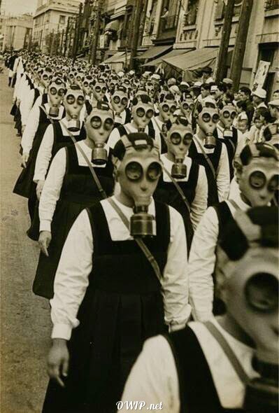 Schoolgirls march the streets wearing gas masks in Tokyo, The Empire of Japan, 1936-1938