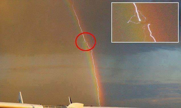 random lightning striking a plane inside a rainbow