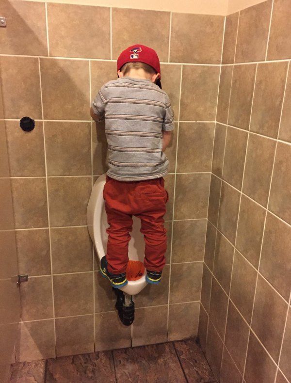 random little boy peeing in urinal