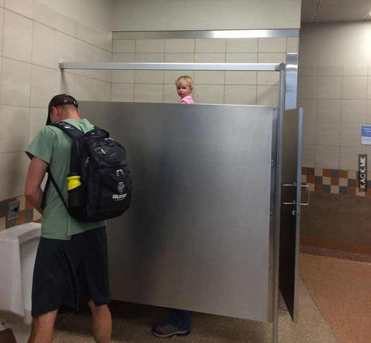 Girl on Dad's shoulders while in the men's room and taller than the stall