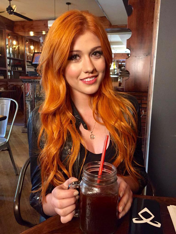 Redhed girl in leather drinking out of a jar at a bar