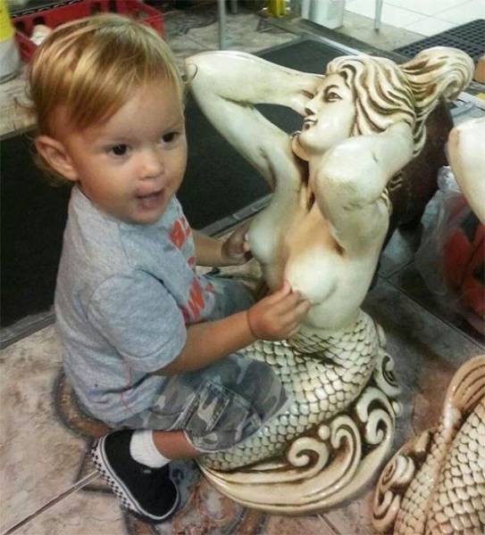 Funny pic of a kid touching a statue in an inappropriate way.