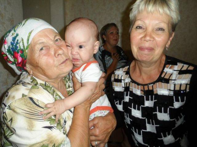 Funny picture of an old woman hugging a child who is reacting not positive to the hug.