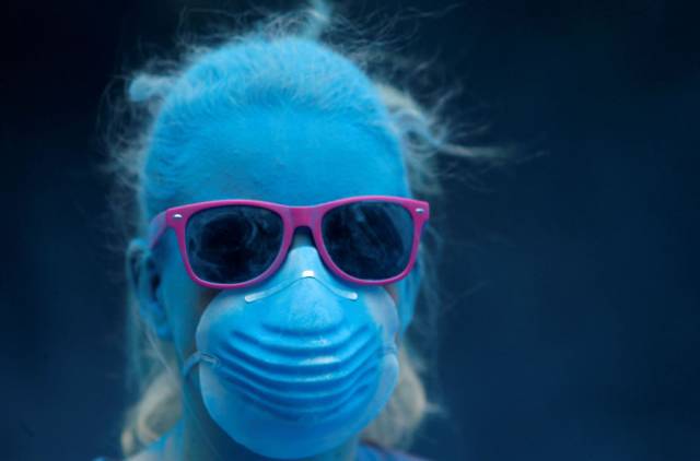 Girl in all blue with a mask of the same color and purple sunglasses.