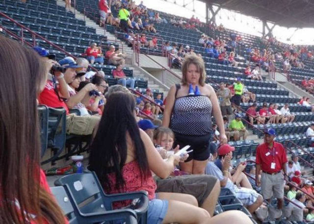 Ballpark photo of a woman with beers stuffed into her top.