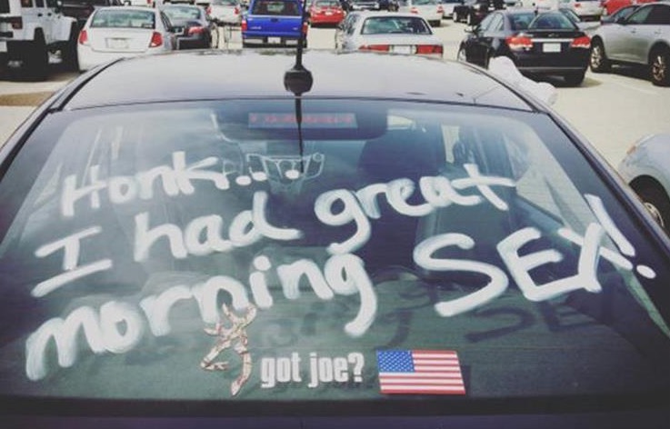 Car with a message on the back window stating "HONK...I Had Great Morning Sex" for all drivers behind to see.
