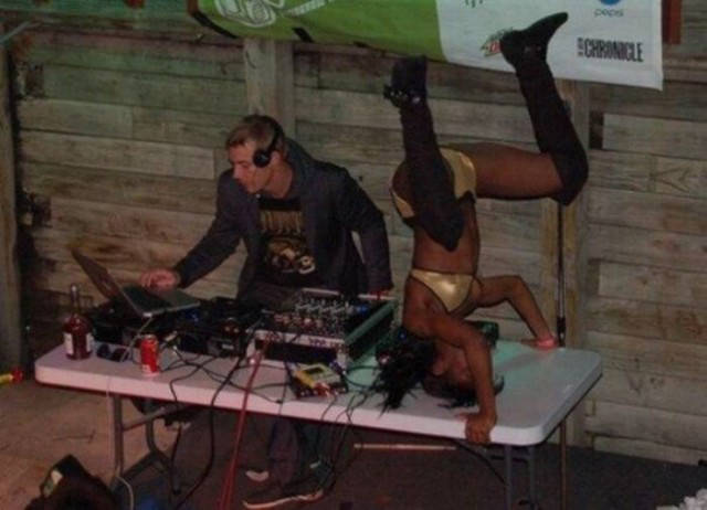 Cringeworthy Russian party pics of DJ doing his thing as woman in golden bikini does handstands on the table.