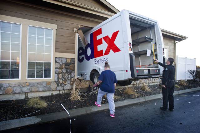 Funny picture of a FedEx truck that delivered a bit too much by driving into the building