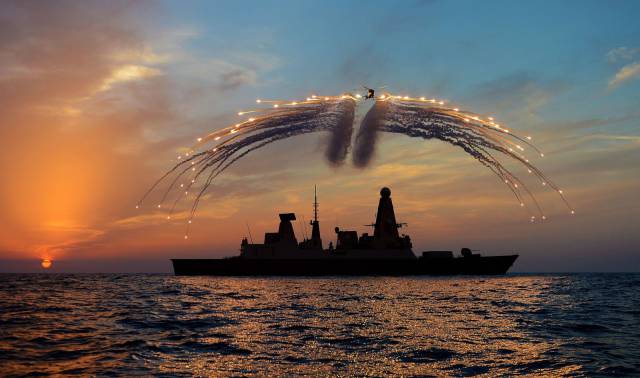 Cool picture of airplane dropping flares over a Navy ship