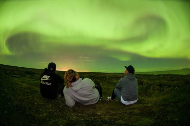 Amazing picture of three friends hanging out under the northern lights