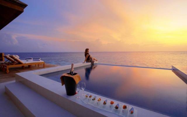 The beautiful balcony overlooking the sea, with a bucket of champagne next to the infinity pool