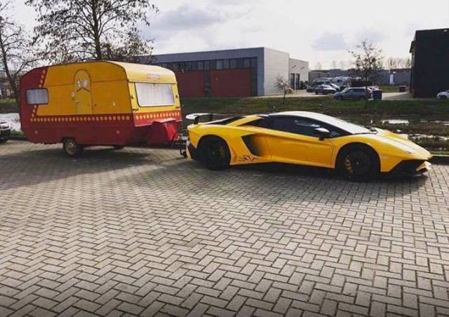 Beautiful yellow Lamborghini pulling a trashy looking trailer.