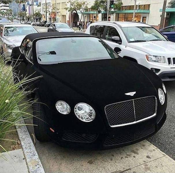 Velvet black Bentley parked on the street.
