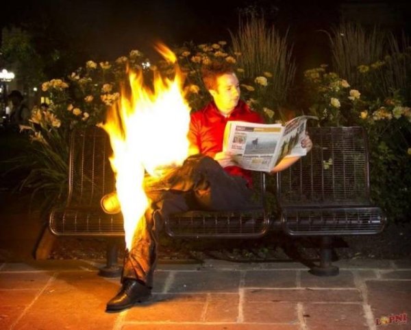 Man on fire reading a newspaper.