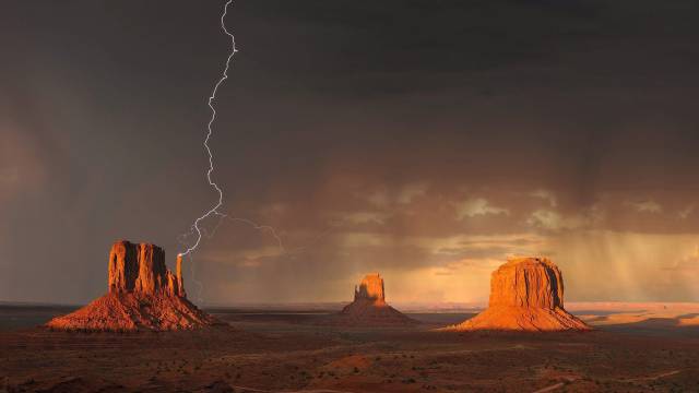 The totem pole butte of Monument Valley gets struck by lightening
