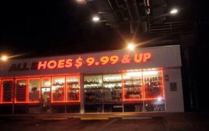 Neon sign that is busted so that it reads Hoes $9.99 and up.