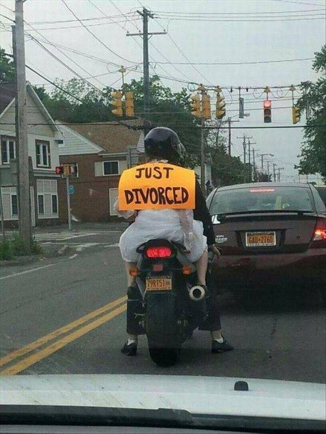 Woman on the back of a motorcycle with sign JUST DIVORCED.