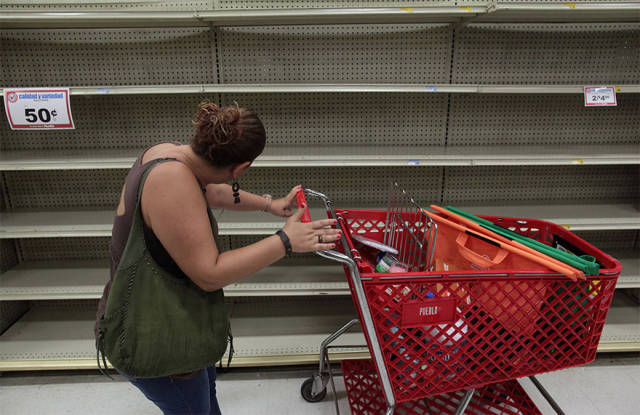 A Woman Looks At Empty Shelves That Are Normally Filled With Bottles Of Water After Puerto Rico Governor Ricardo Rossello Declared A State Of Emergency In San Juan, Puerto Rico