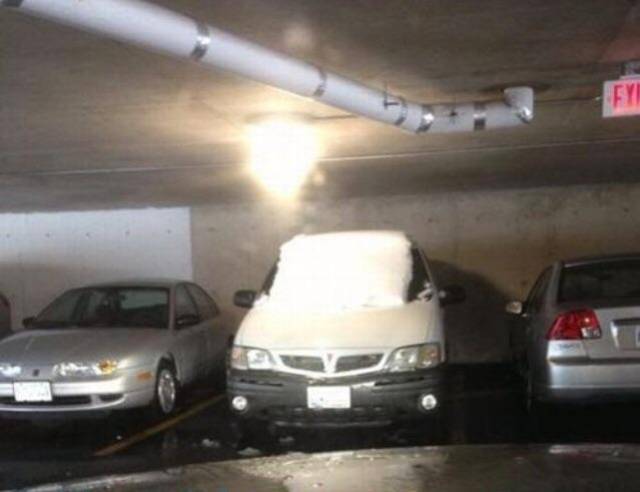 Car covered in snow in the underground parking garage