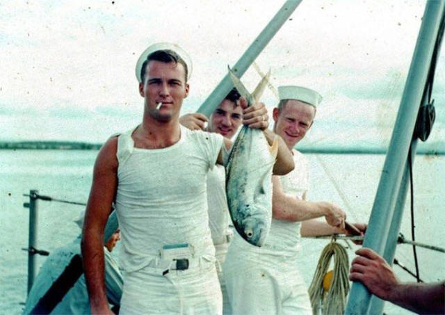 Very Cool Grandpa In The 1950s Holding A Fish, Smoking A Cigarette, With A Book Tucked Into His Pants And Cigarette Pack In His Sleeve