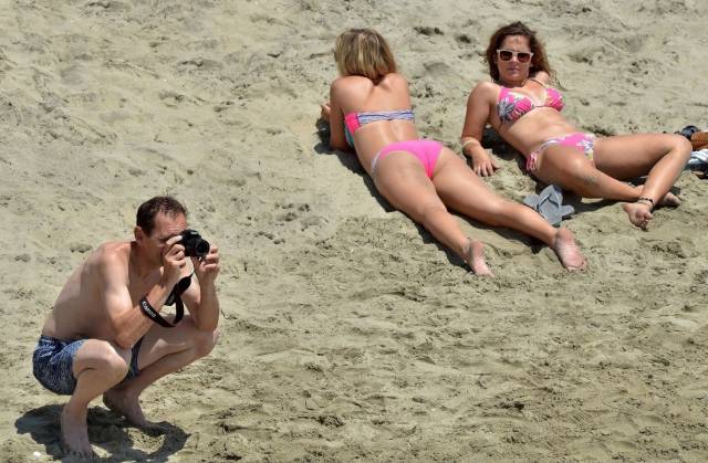 carefree funny pics of - a man taking a photo of the beach