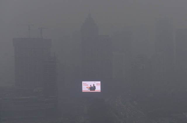 A bright billboard drowning in a thick smog in China-Rapid industrial development causes 85% of people on our planet to breathe in polluted air.