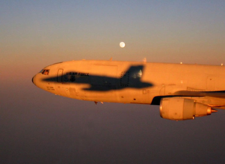 airplane with shadow of fighter jet on its main fusalagef