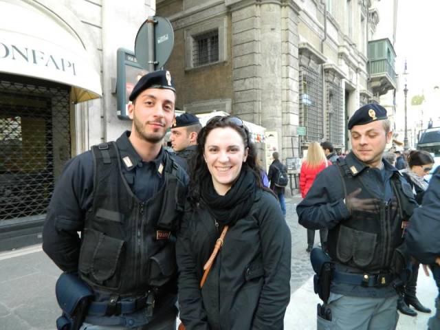 girl posing for picture with police and one of the men is checking her out