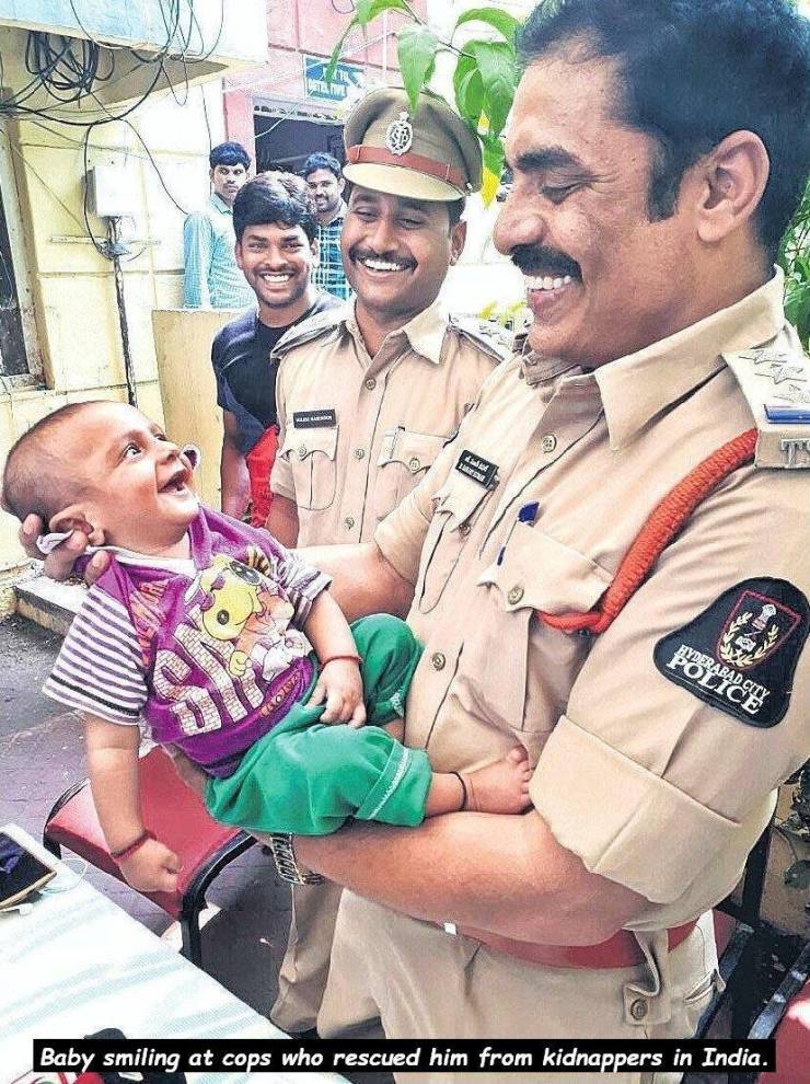 hyderabad cops pic with kidnapped child - Felpdee Baby smiling at cops who rescued him from kidnappers in India.