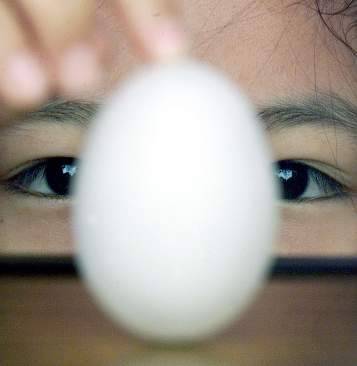 Taiwanese girl balances an egg on its end during the Dragon Boat Festival