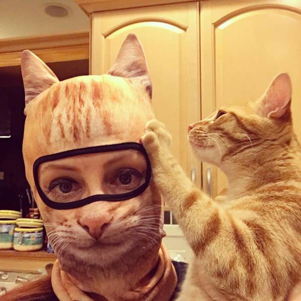 funny pics - woman wearing cat mask with her pet cat