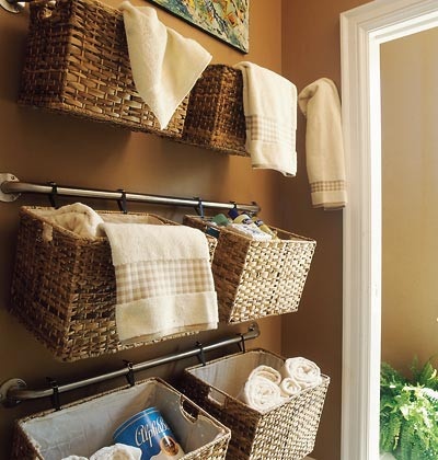 Hang baskets on curtain rods to take advantage of unused wall space. The baskets can be attached with zip ties or  S-hooks I think that's the proper name for them. This is a perfect idea for storing extra hand towels in the bathroom, organizing kids' toys, keeping craft items together, or even storing items in the garage.