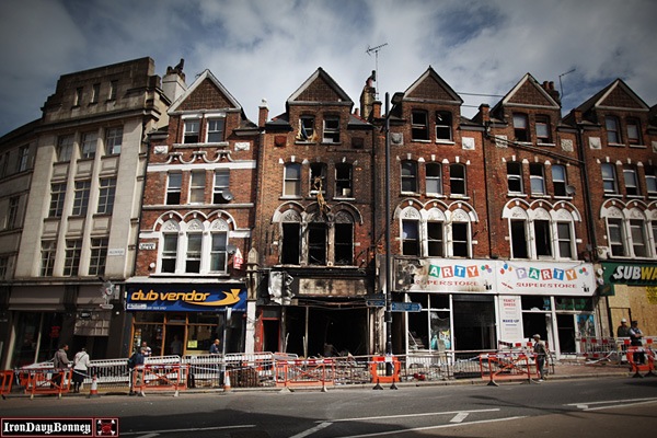 Continued Destruction in London - People walk past fire-damaged shops and flats in Clapham Junction.