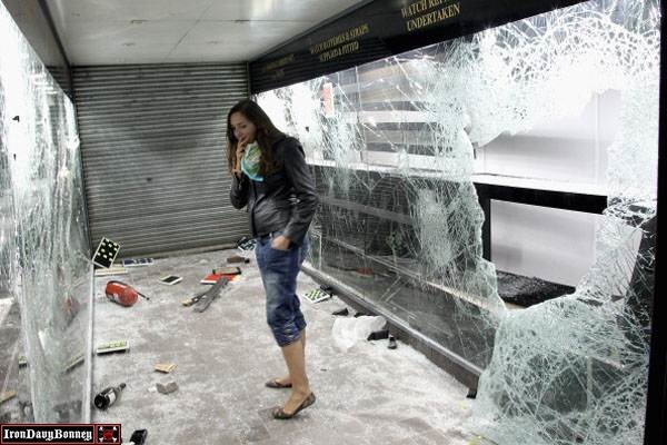 Riots And Looting Continues Across London #1 - A girl looks at damage caused by looters in a pawn shop on Clapham High Street.