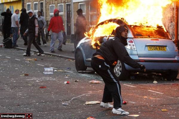 Riots And Looting Continues Across London #4 - A rioter throws a rock at riot police in Clarence Road in Hackney.