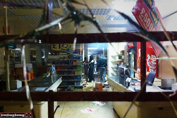 Looters in Tottenham - Youths use aerosol cans to set fire to shelves of goods inside a retail store.
