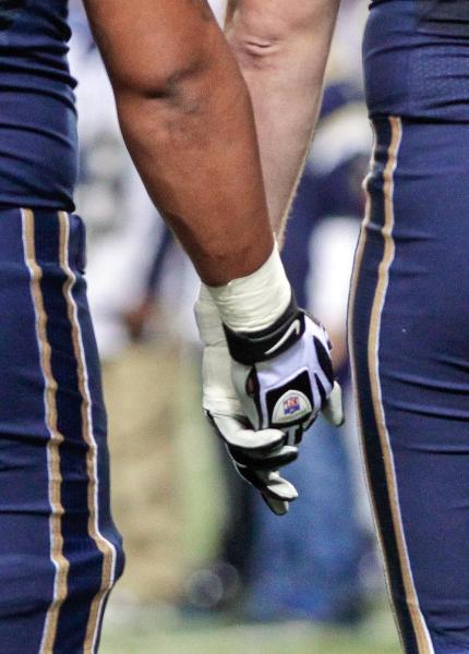 Members of the St. Louis Rams hold hands during a moment of silence