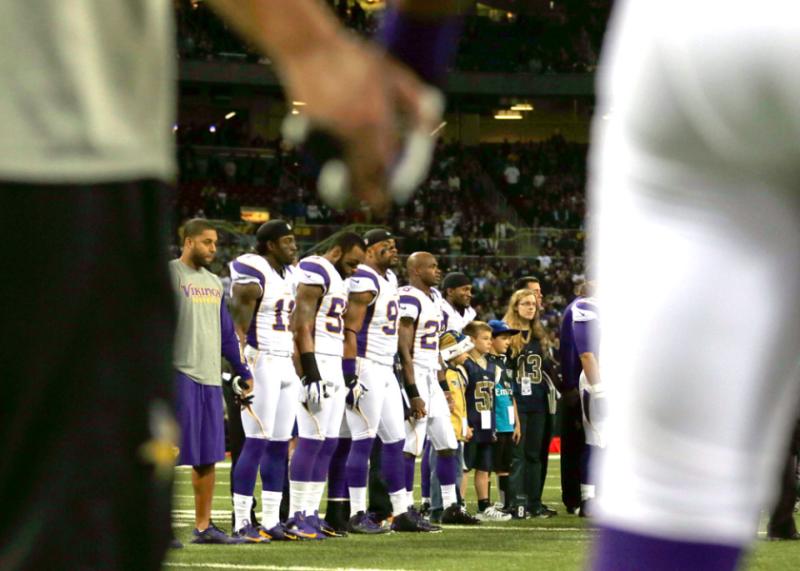 Members of the Minnesota Vikings hold hands during a moment of silence before their game in St. Louis against the Rams.