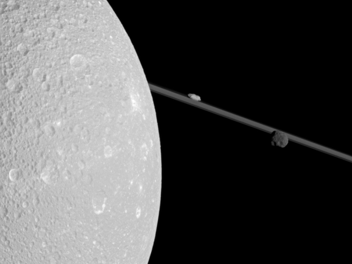 Flying past Saturn's moon Dione, Cassini captured this view which includes two smaller moons, Epimetheus and Prometheus, near the planet's rings.