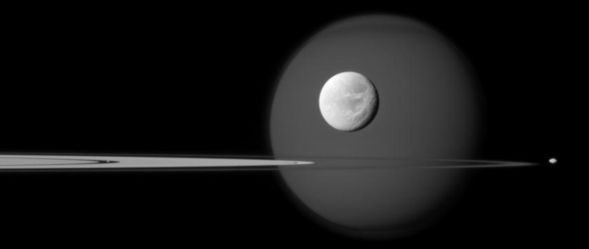 A quartet of Saturn's moons, from tiny to huge, surround and are embedded within the planet's rings in this Cassini composition.