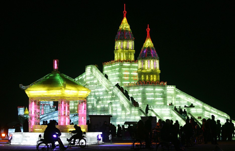 Tourists view sculptures and buildings built from ice blocks at the Harbin International Ice and Snow World.