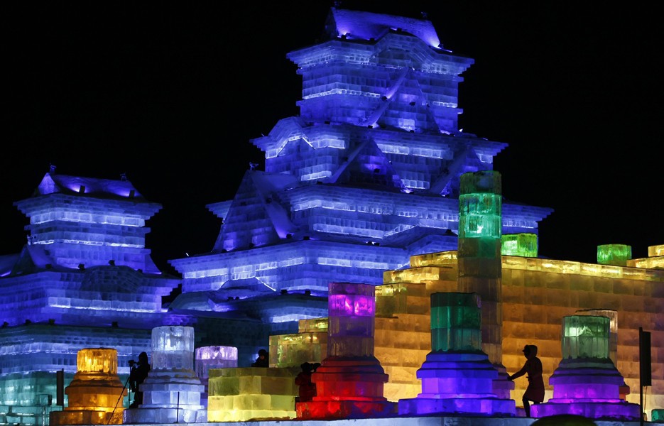 At the Harbin International Ice and Snow Sculpture Festival's Ice and Snow World, visitors admire massive sculptures and buildings built from ice blocks cut from a nearby river.