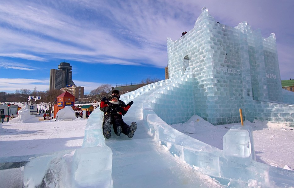 Visitors slide down an ice sculpture in Quebec City, Canada, at the Quebec Winter Carnival.