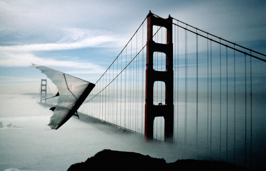 A hang glider soars above San Francisco's Golden Gate Bridge.
