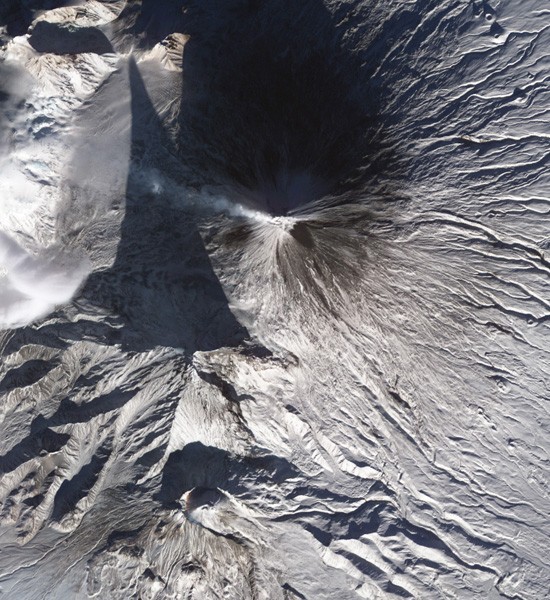 Russia's Klyuchevskaya volcano emitted a white plume of ash and steam over its snow-covered slopes