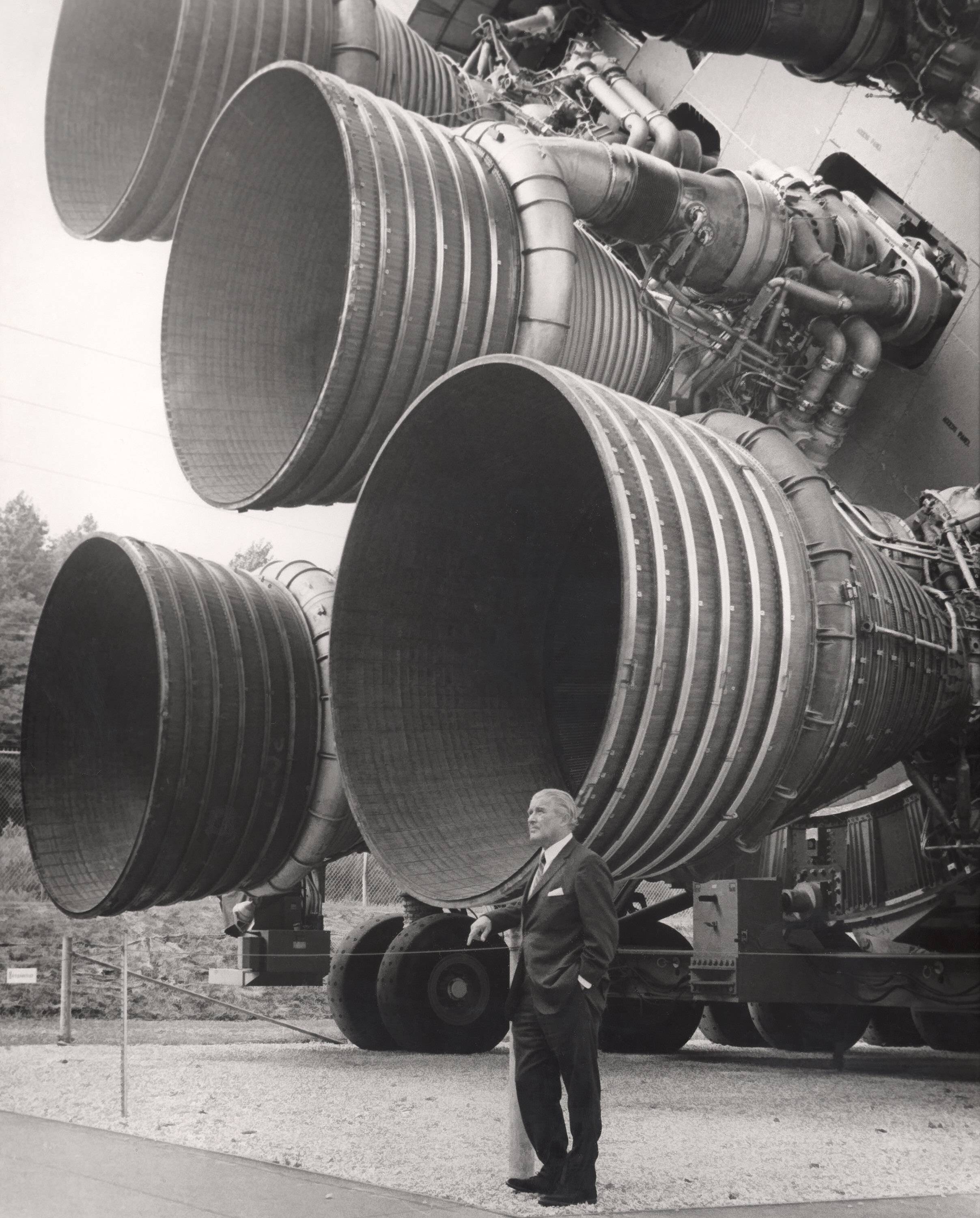 Wernher von Braun standing next to the F-1 engines on the Apollo rocket